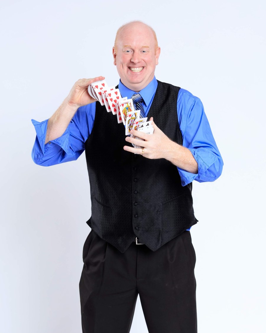 Scott Henderson studio portrait with cards in mid-flourish